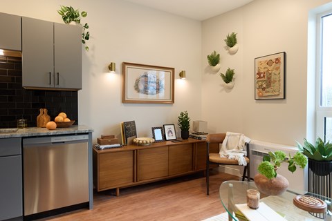 A modern kitchen with a wooden cabinet and a framed picture on the wall.