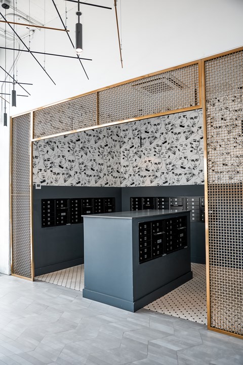 A kitchen with a black and white patterned backsplash and a wooden screen.