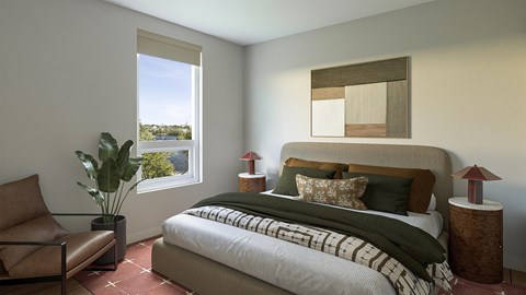 A bedroom with a large bed and a chair.