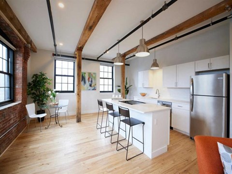 A kitchen with a white counter and a refrigerator.