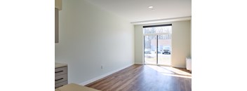 A room with a tan sofa and a white wall.