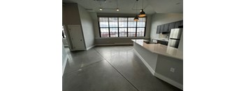 A large, empty kitchen with a view of the city through the window.