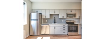 A modern kitchen with a stainless steel refrigerator and oven.