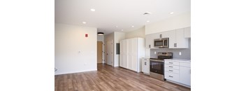 A kitchen with white cabinets and a stainless steel oven.