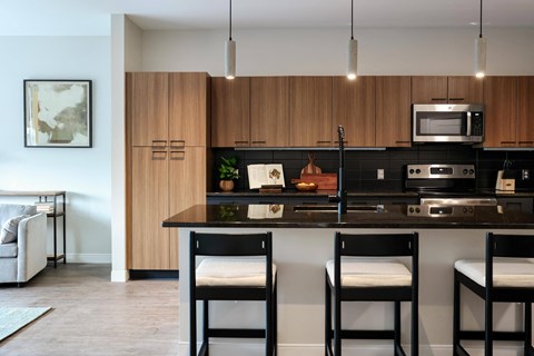 A kitchen with a black countertop and wooden cabinets.
