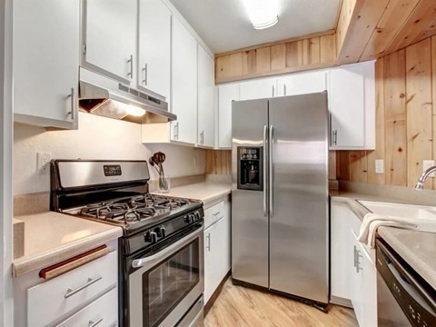 a kitchen with stainless steel appliances and white cabinets