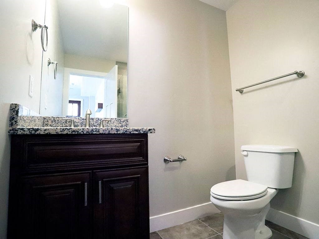 Downstairs Bathroom With Mirror, Marble Counters, Light Fixture, and Toilet at Moenave Townhomes in Springdale, Utah