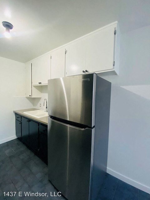 a kitchen with a stainless steel refrigerator and white cabinets