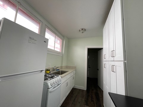 a kitchen with white appliances and a stove and a refrigerator