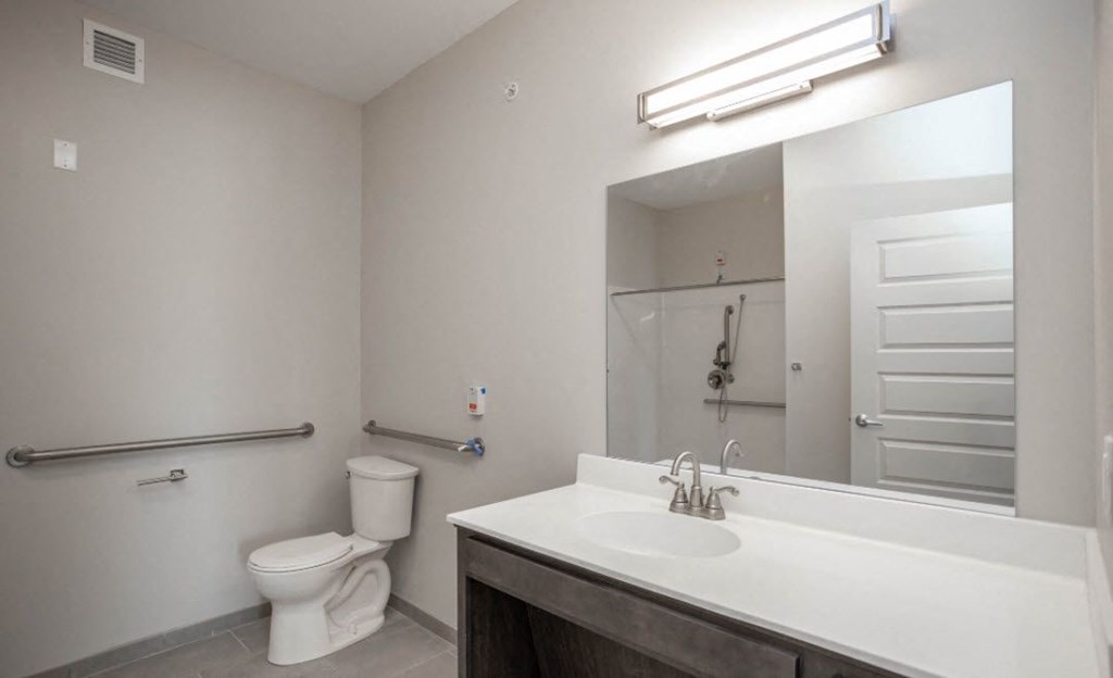 a bathroom with a sink toilet and a mirror