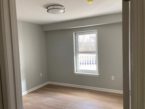 Bedroom an empty room with a window and wooden floors
