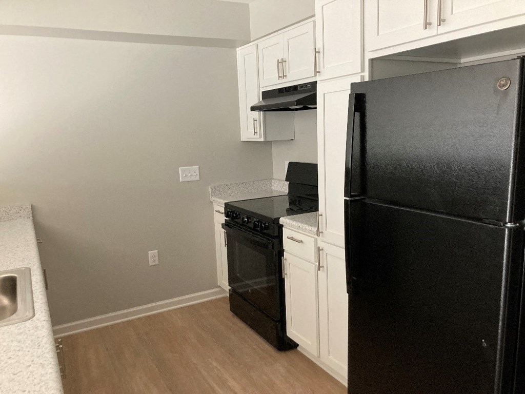 a kitchen with black appliances and white cabinets