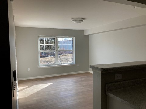 Living Room a living room with a large window and wooden floors