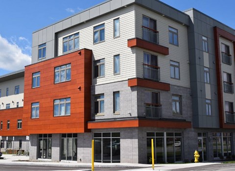 A modern multi-story building with a combination of red and grey exterior.