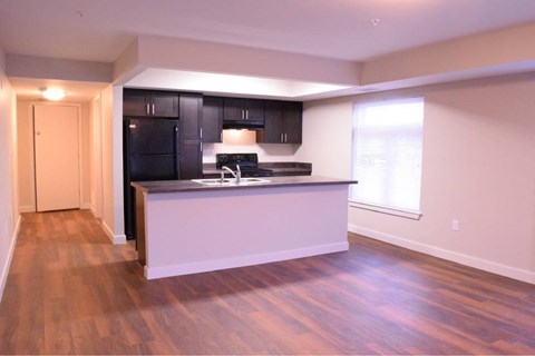 A kitchen with black cabinets and a white island.