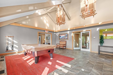 A room with a red rug and a wooden table.