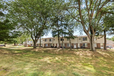 Two story apartment buildings with mature trees at Indian Valley Apartments, Kent, OH