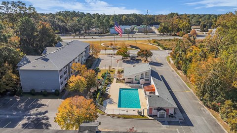 An aerial view of a school with a pool and a flag.