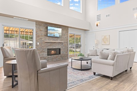 A living room with a stone fireplace and a painting above it.
