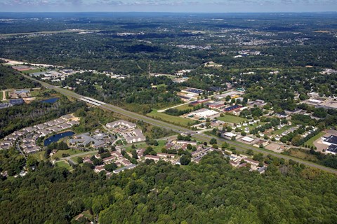 an aerial view of a city with a highway and trees