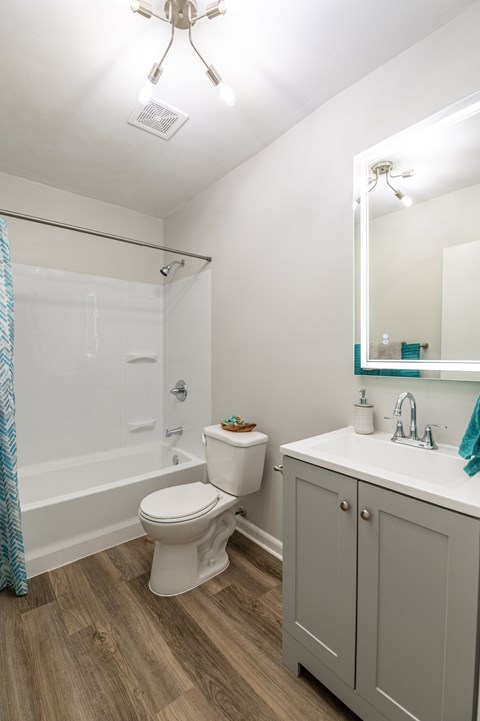 A white toilet sits in a bathroom next to a sink.