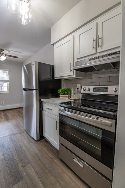 A modern kitchen with a stainless steel refrigerator and oven.