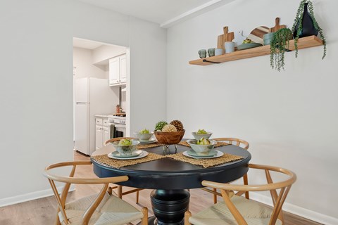 A dining room with a round table and chairs.