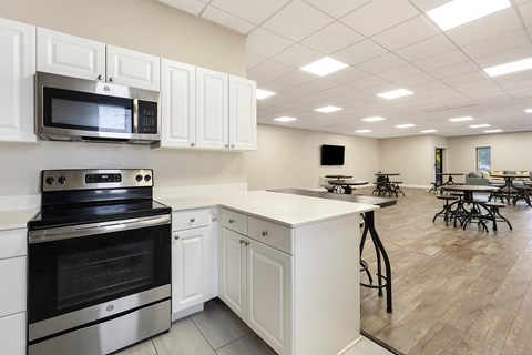 A kitchen with white cabinets and a black stove top oven.