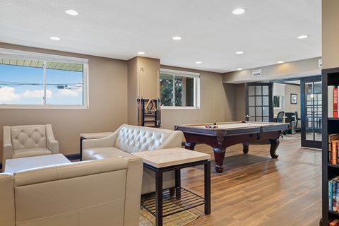 A room with a pool table and a chair.