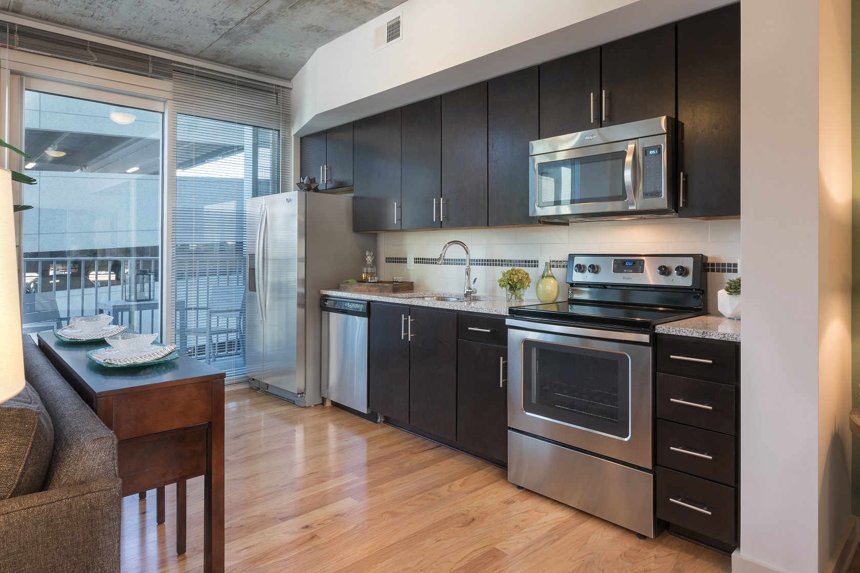 A modern kitchen with black cabinets and stainless steel appliances.
