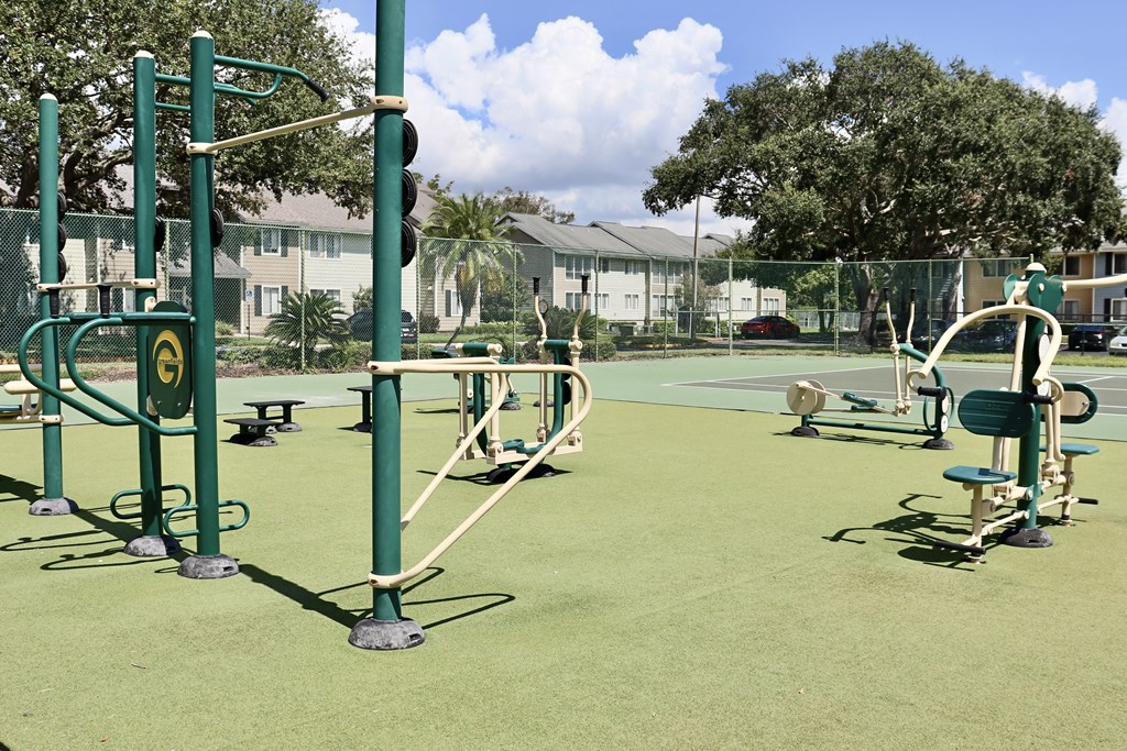 A playground with green equipment and a green fence.