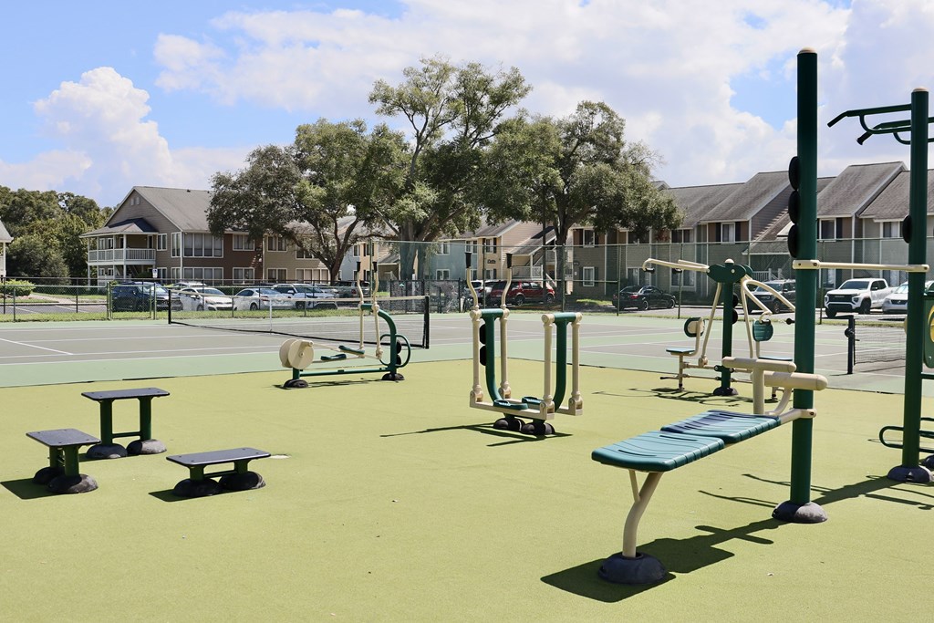 A playground with a green surface and a blue bench.