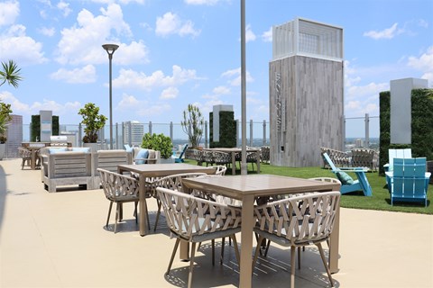 A modern outdoor dining area with wooden tables and chairs.