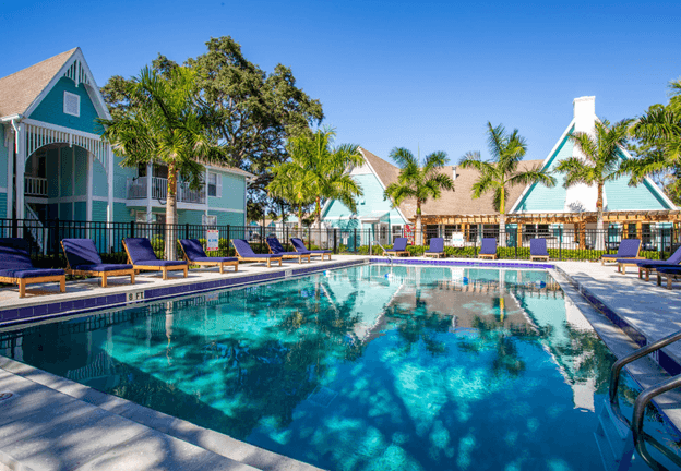 a large swimming pool with lounge chairs in front of a house