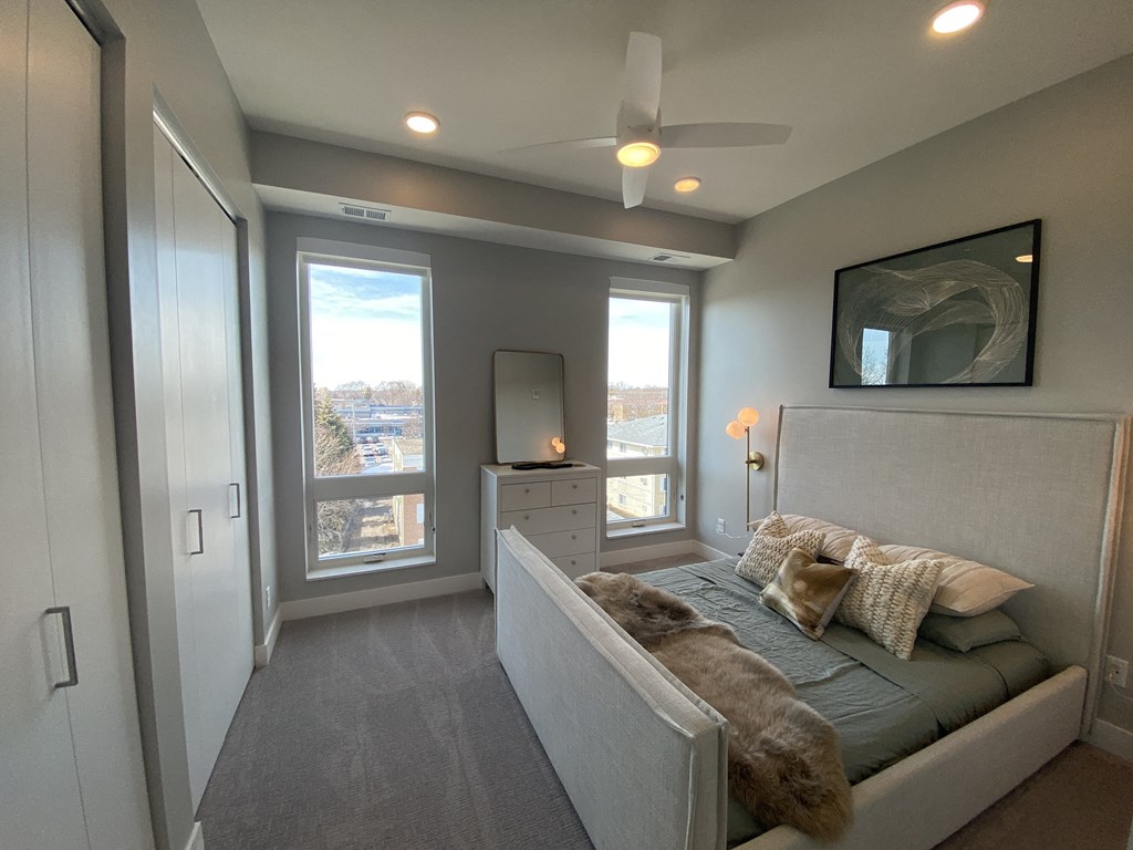 a bedroom with a bed and a ceiling fan