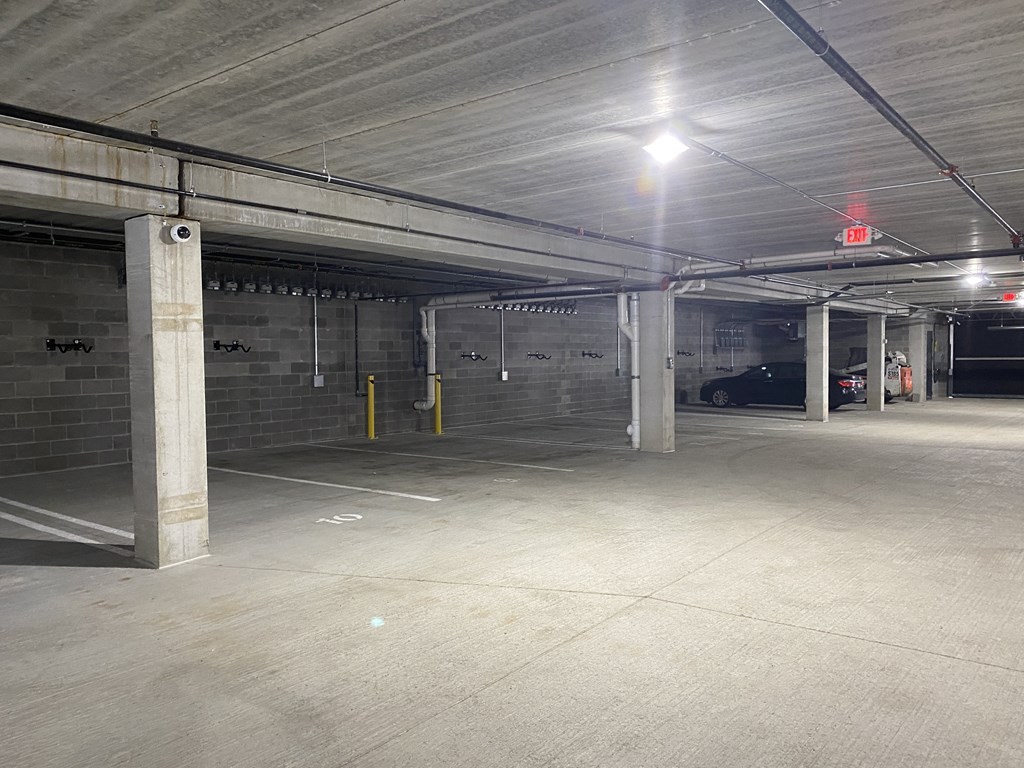 an empty parking garage with a car parked in the distance