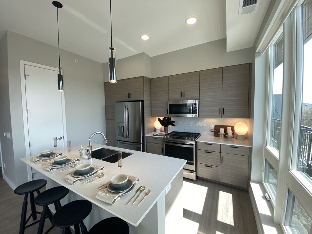 a kitchen with gray cabinets and a white island