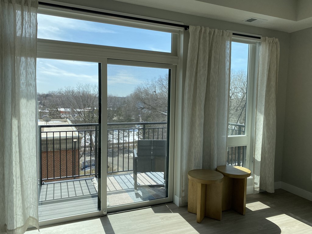 a bedroom with a large window and a balcony