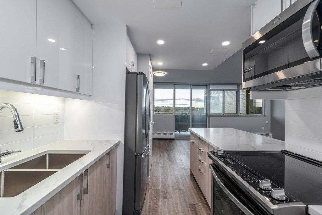 Renovated kitchen with white upper cabinets and light wood lower cabinets