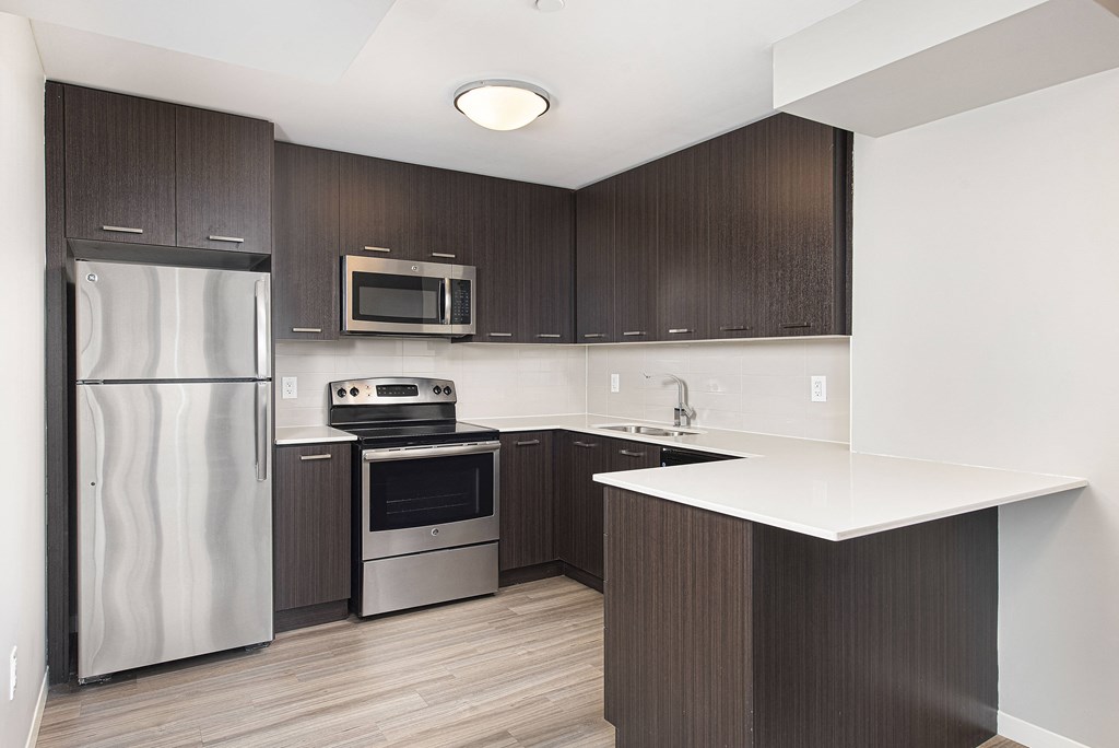a kitchen with stainless steel appliances and a white counter top