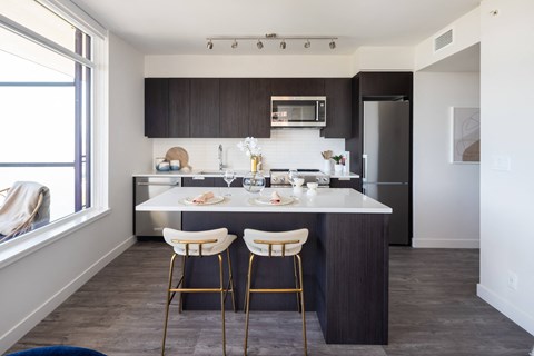 a kitchen with a marble counter top and two stools