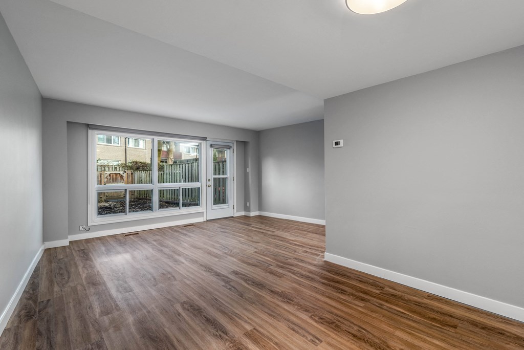 Open concept living room and dining room with large windows
