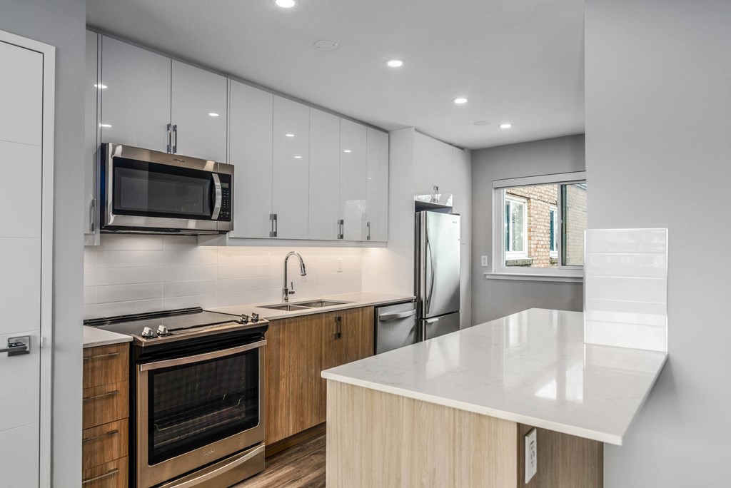Kitchen with white upper cabinets and light wood lower cabinets