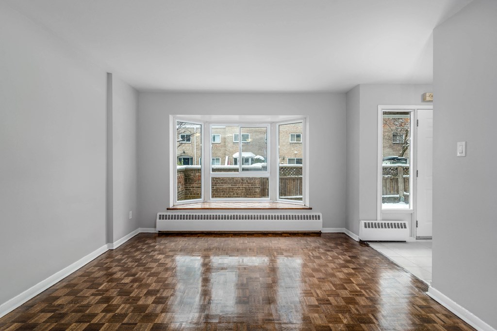 Living room and dining room with a big window overlooking a patio