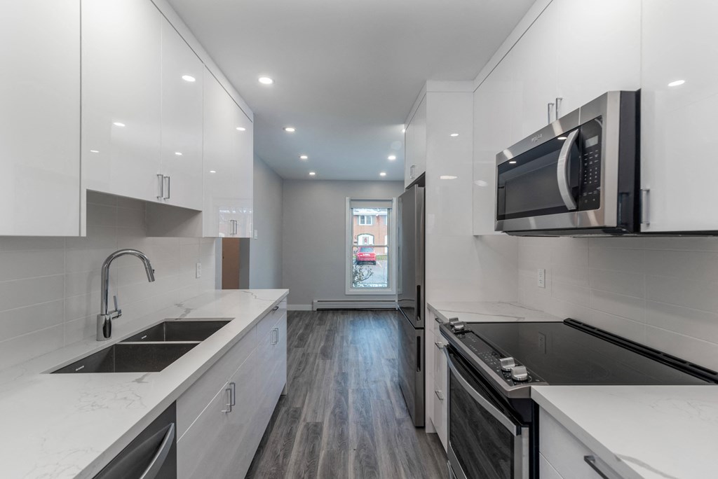 Renovated kitchen with white cabinets and stainless steel appliances