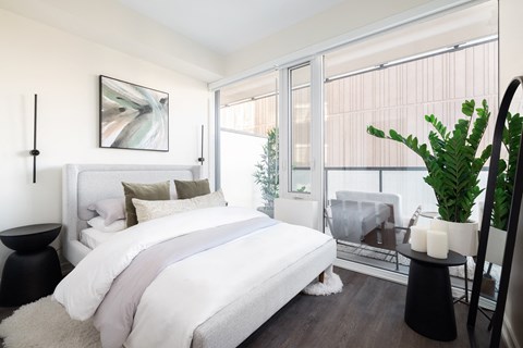 A bedroom with a large bed and a painting on the wall.