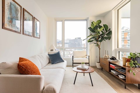 A living room with a white couch and a large window.