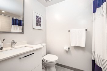 Bathroom appointed with white quartz countertops and chrome fixtures.