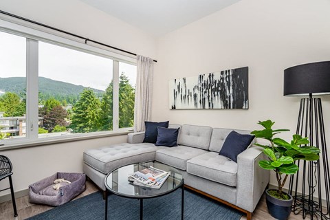 a living room with a couch and a table and a window