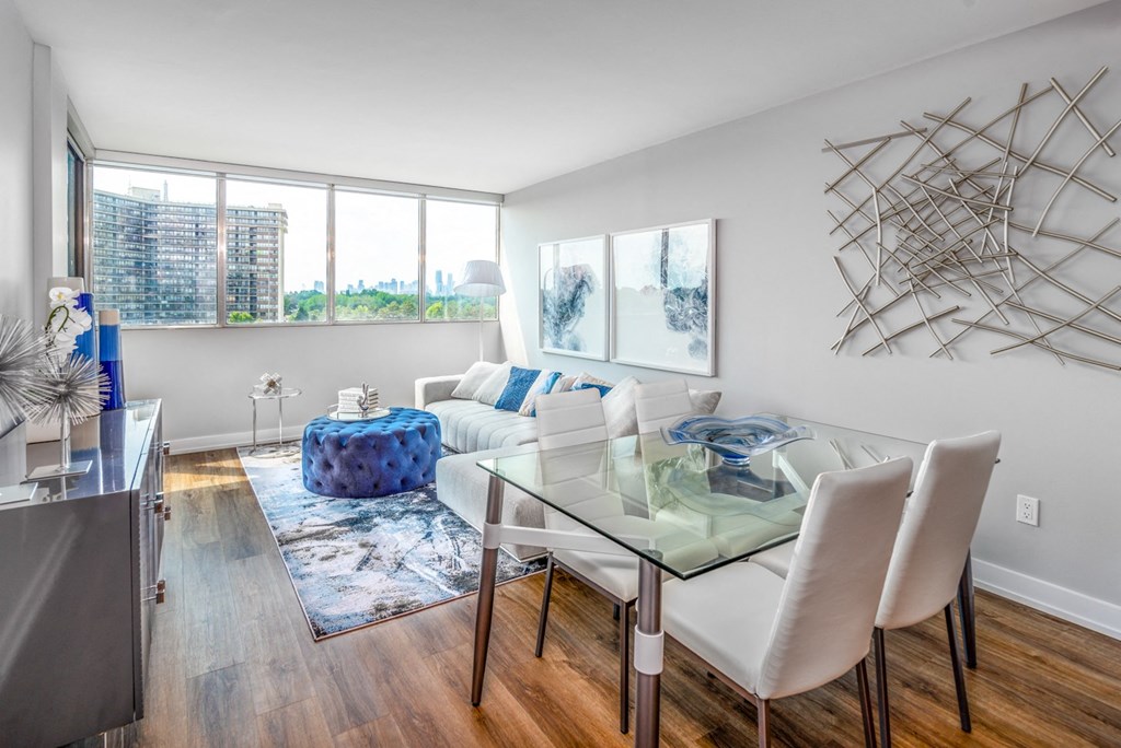 Open concept living and dining room staged with furniture.